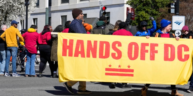 Demonstrators hold a banner during a protest in front of the Dirksen Senate Office Building, Wednesday, March 8, 2023, on Capitol Hill in Washington.