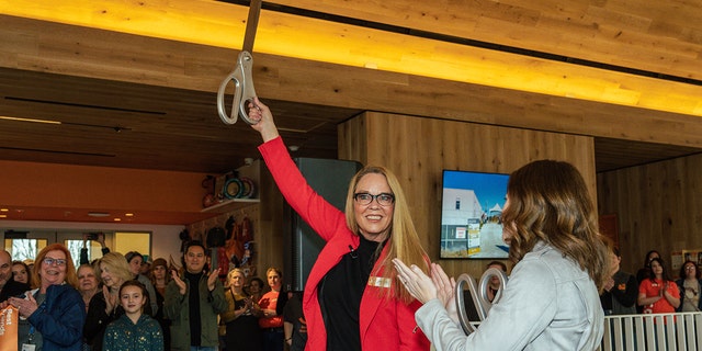 Best Friends Animal Society CEO Julie Castle holds up a pair of scissors after cutting the ribbon and officially opening the brand new Best Friends Pet Resource Center in Bentonville, Arkansas, on March 11, 2023.