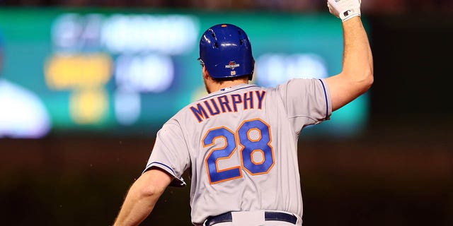 El número 28 de los Mets de Nueva York, Daniel Murphy, da vueltas por las bases después de pegar un jonrón de dos carreras en la octava entrada contra el número 57 de los Cachorros de Chicago, Fernando Rodney, en el Juego 4 de la Serie de Campeonato de la Liga Nacional de la MLB de 2015 en el Wrigley Field en octubre. 21, 2015 en Chicago.