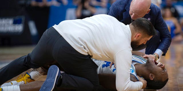 UCLA guard David Singleton yells as he is treated by the team's coach, as coach Mick Cronin joins them, during the second half of the team's second round college basketball game against Northwestern in the NCAA Men's Tournament , on Saturday, March 18, 2023, in Sacramento.  , california