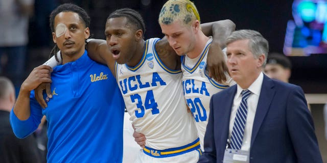 UCLA guard David Singleton (34) is helped off the court during the second half of the team's second-round college basketball game against Northwestern in the men's NCAA Tournament in Sacramento, Calif., Saturday, March 18, 2023.