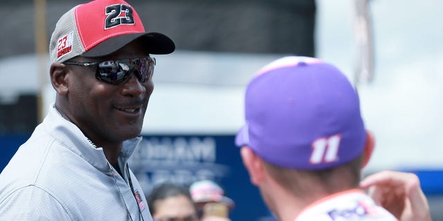 El miembro del Salón de la Fama de la NBA, Michael Jordan, se reúne con el copropietario de 23XI Racing, Denny Hamlin, conductor del Toyota FedEx Ground n.° 11, antes de la Pocono Organics CBD 325 de la NASCAR Cup Series en Pocono Raceway el 26 de junio de 2021 en Long Pond, Pensilvania. 