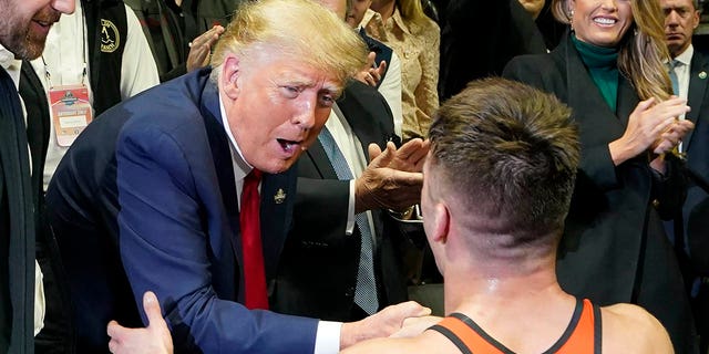 Former President Donald Trump, left, congratulates Princeton wrestler Pat Glory after Glory won the NCAA Wrestling Championship at the 125-pound class, Saturday, March 18, 2023, in Tulsa, Oklahoma.