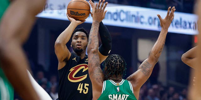Cleveland Cavaliers guard Donovan Mitchell, #45, shoots a 3-point basket against Boston Celtics guard Marcus Smart, #36, during the first half of an NBA basketball game, Monday, March 6, 2023, in Cleveland. 