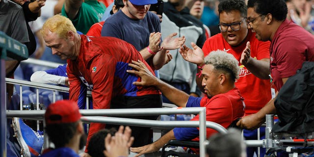 El lanzador de Puerto Rico Edwin Díaz, No. 39, sale del campo en silla de ruedas después de una aparente lesión en la pierna durante la celebración del equipo contra la República Dominicana en el LoanDepot Park en Miami el 15 de marzo de 2023.