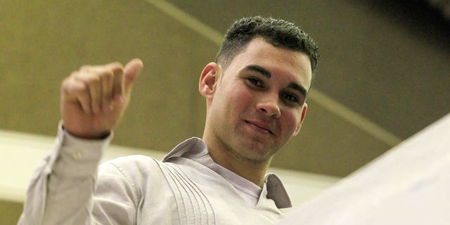 Cuban shipwreck survivor Elian Gonzalez gestures after a speech by Cuban President Raul Castro at the National Assembly in Havana, December 20, 2014. The deal that ended decades of open hostility with the United States.
