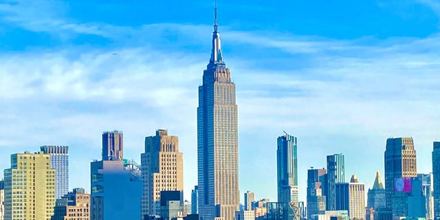 The Empire State Building, as seen from the 42nd floor of a residential building on 42nd Street, standing singularly over the Midtown Manhattan skyline. 