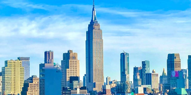 The Empire State Building, as seen from the 42nd floor of a residential building on 42nd Street, standing singularly over the Midtown Manhattan skyline. 