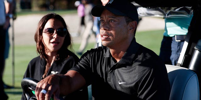 Tiger Woods and Erica Herman ride in a cart before the Pro-Am before the PNC Championship at the Ritz Carlton Golf Club Grande Lakes on December 17, 2021 in Orlando, Florida.