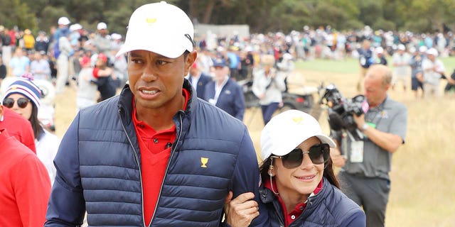 Tiger Woods de los Estados Unidos y su novia Erica Herman celebran después de ganar la Copa Presidentes del 16 al 14 de diciembre de 2019 en Melbourne, Australia.