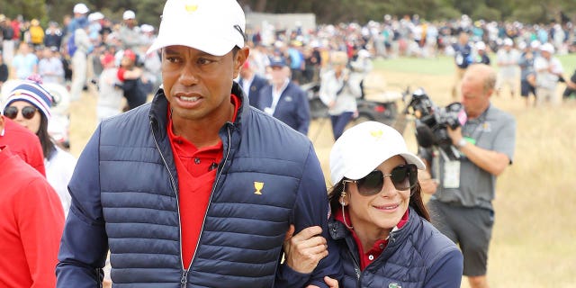 Tiger Woods de los Estados Unidos y su novia Erica Herman celebran después de ganar la Copa Presidentes del 16 al 14 de diciembre de 2019 en Melbourne, Australia.