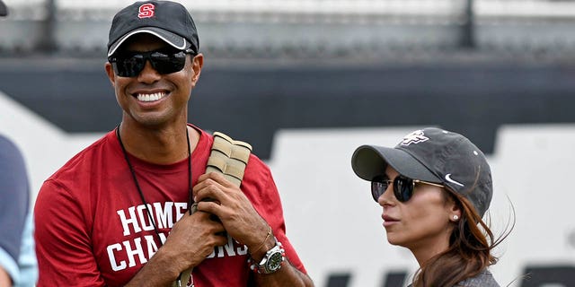 PGA golfer Tiger Woods, left, and girlfriend Erica Herman look on prior to the game between the UCF Knights and the Stanford Cardinals at Spectrum Stadium in Orlando, Florida, Sept. 14, 2019.