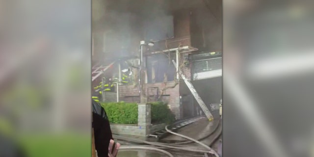 FDNY firefighters are seen heading into a smoking building in the Woodside neighborhood.