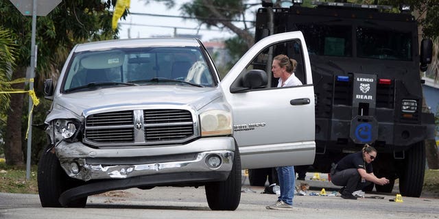 Fort Lauderdale Police work at the scene where they shot and killed a murder suspect, Manuel Sanabria, in Fort Lauderdale, Florida, on March 7, 2023.