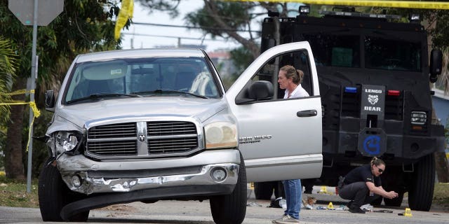 Fort Lauderdale Police work at the scene where they shot and killed a murder suspect, Manuel Sanabria, in Fort Lauderdale, Florida, on March 7, 2023.