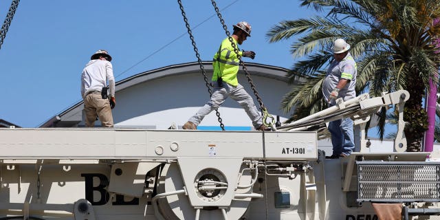 Work crews assemble the cranes that will be used to dismantle the Orlando FreeFall at ICON Park, on March 14, 2023 in Orlando, Florida.