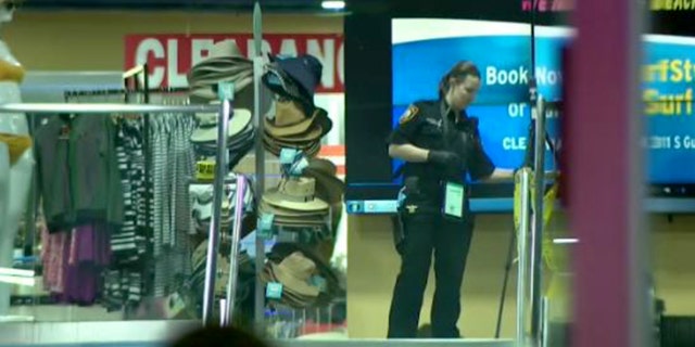 Clearwater police investigator inside a surf shop after police say an argument led to a shooting, killing one.