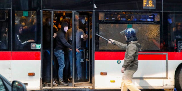 Aficionados del equipo de fútbol Eitracht Frankfurt son sometidos y llevados en un autobús después de un enfrentamiento con la policía el miércoles 15 de marzo de 2023 en Nápoles, Italia, donde su equipo se prepara para jugar un partido de vuelta de los octavos de final de la Liga de Campeones contra Napoli .