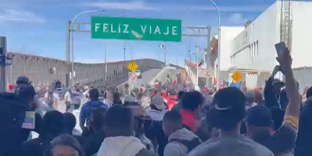 A group of migrants rushed across the bridge connecting Mexico and El Paso, Texas, on Sunday.