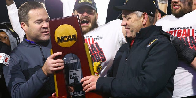 Head coach Tony Annese of the Ferris State Bulldogs receives the national championship trophy after defeating the Valdosta State Blazers for the Division II football title at McKinney ISD Stadium Dec. 18, 2021, in McKinney, Texas.