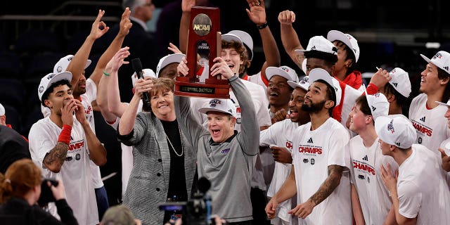 Florida Atlantic head coach Dusty May holds up the championship trophy after Florida Atlantic defeated Kansas State 79-86 in an Elite 8 college basketball game in the NCAA Tournament's East Region final, Saturday, March 25, 2023, in New York.
