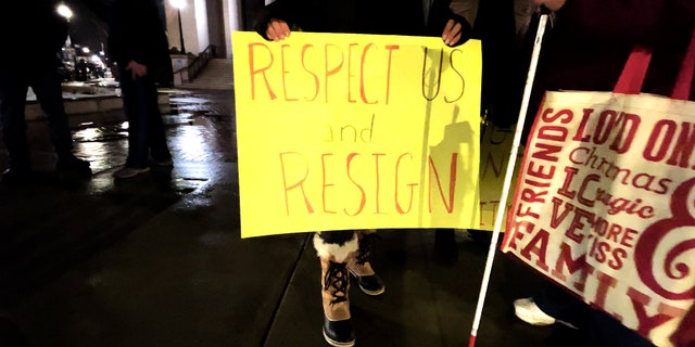 Tanda protes di luar balai kota Framingham menyerukan agar Michael Hugo mengundurkan diri menyusul komentar kontroversialnya tentang aborsi.