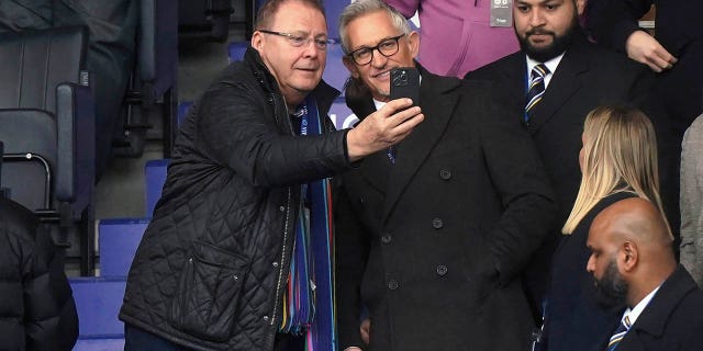 Soccer broadcaster Gary Lineker, center right, poses for photographs with a fan in the stands ahead of the English Premier League match between Leicester City and Chelsea at King Power Stadium in Leicester, England, March 11, 2023.