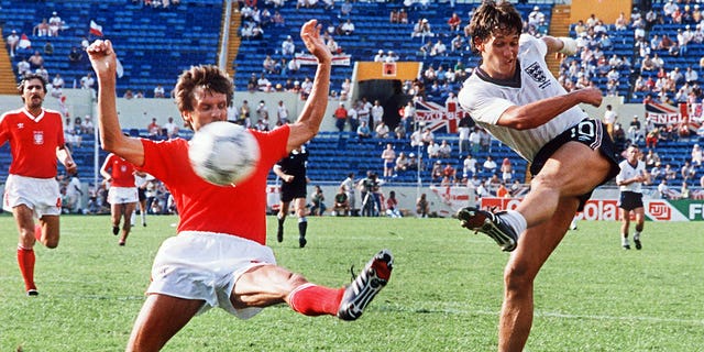 El delantero de Inglaterra Gary Lineker, a la derecha, patea el balón y pasa al defensor de Polonia Stefan Majewski durante el primer partido de fútbol de la Copa Mundial entre Inglaterra y Polonia el 11 de junio de 1986 en Monterrey, México.