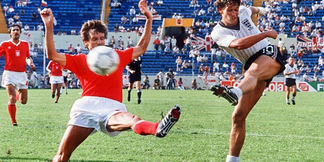 El delantero de Inglaterra Gary Lineker, a la derecha, patea el balón pasando al defensor polaco Stefan Majewski durante el partido de la primera ronda de la Copa del Mundo el 11 de junio de 1986 en Monterrey, México.