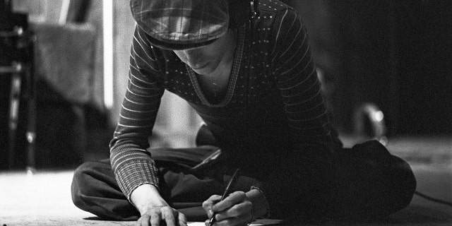David Bowie writing song lyrics in a quiet moment captured by his childhood friend.