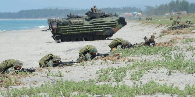 Philippine marines take position near U.S. Marine Corps amphibious assault vehicles during an exercise in the San Antonio region of the Philippines on Oct. 6, 2018.
