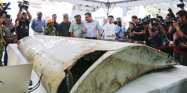 Malaysian Minister of Transport Anthony Loke, center, looks at a wing flap found on Pemba Island, Tanzania, which has been identified as a missing part of Malaysia Airlines Flight MH370 through unique part numbers traced to 9M-MRO during a commemoration event to mark the fifth anniversary of the missing Malaysia Airlines MH370 flight in Kuala Lumpur, Malaysia, March 3, 2019. 