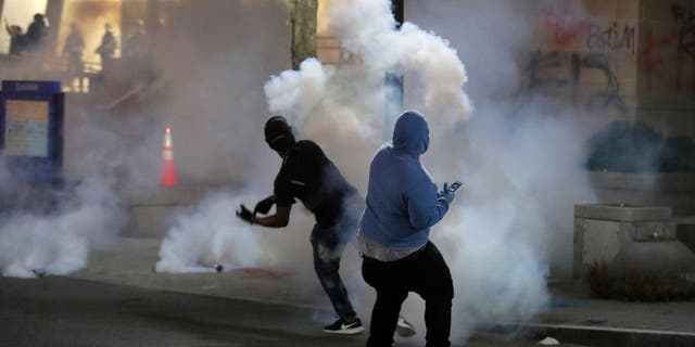 Protesters throw back tear gas in downtown Raleigh, North Carolina, Saturday, May 30, 2020 