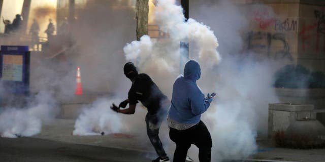 Protesters throw tear gas back at the police on Saturday, May 30, 2020 in downtown Raleigh, NC 