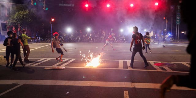 CMPD officers deploy a stun grenade during a demonstration for the end of police brutality in uptown Charlotte, North Carolina, on June 2, 2020.