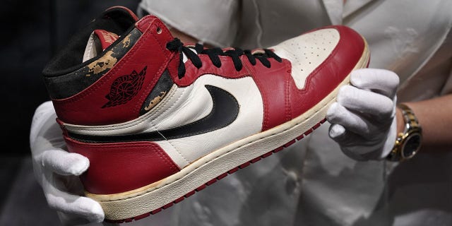 Caitlin Donovan, Christie's head of sales, handbags and accessories, holds the Air Jordan 1 High "Shattered Backboard" Origin Story, Game-Worn Signed Sneaker Nike, 1985 Size 13.5 High-Top on display during a press preview on July 24, 2020, at Christie's New York. Christie's and Stadium Goods partnered to offer a unique sneaker overview of Michael Jordan's era-defining Chicago Bulls career.