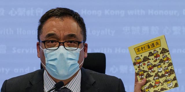 Hong Kong Senior Superintendent Steve Lee of the city's new National Security Police unit holds a children's book that allegedly attempts to explain the city's democracy movement at a police press conference in Hong Kong on July 22, 2021, after five members of Hong Kong's pro-democracy union were arrested for incitement to mutiny for publishing the titles. 