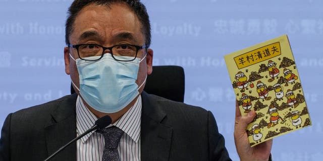 Hong Kong's senior superintendent Steve Li, from the city's new national security police unit, holds up a children's book which allegedly tries to explain about the city's democracy movement, at a police press conference in Hong Kong on July 22, 2021, after five members of a pro-democracy Hong Kong union were arrested for sedition for publishing the titles. 