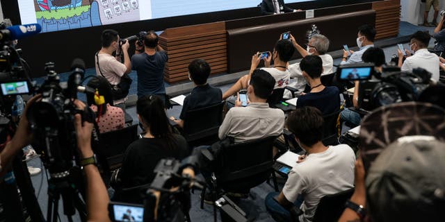 Contents of children's books are displayed on a television screen during a news conference after five people were arrested on suspicion of conspiring to publish inflammatory material at the Hong Kong Police Headquarters in Hong Kong, China, July 22, 2021. 