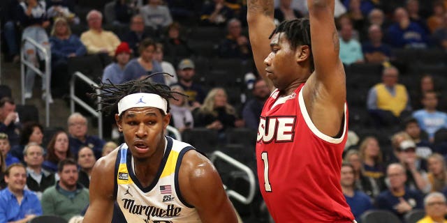 Marquette Golden Eagles forward Justin Lewis, #10, flips over SIU Edwardsville Cougars forward DeeJuan Pruitt, #1, during a game between the Marquette Golden Eagles and the Edwardsville Cougars of Southern Illinois University at the Fiserv Forum on November 9, 2021 in Milwaukee.