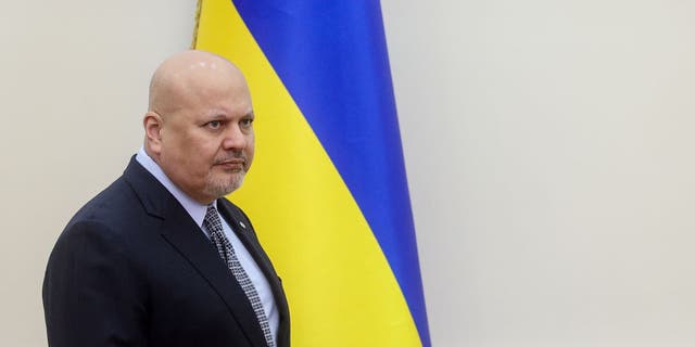 The Prosecutor of International Criminal Court Karim Ahmad Khan stands in front of Ukrainian flag as he visits Kyiv and territories which were occupied by Russia in Ukraine, April 14, 2022. 