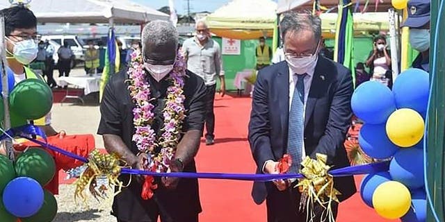 Duta Besar China untuk Kepulauan Solomon, Li Ming, kanan, dan Perdana Menteri Solomon Manasseh Sogavare memotong pita saat upacara pembukaan kompleks stadion nasional yang didanai China di Honiara pada 22 April 2022.