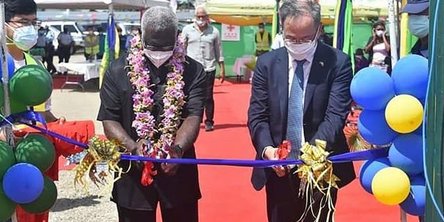 Duta Besar China untuk Kepulauan Solomon, Li Ming, kanan, dan Perdana Menteri Solomon Manasseh Sogavare memotong pita saat upacara pembukaan kompleks stadion nasional yang didanai China di Honiara pada 22 April 2022.