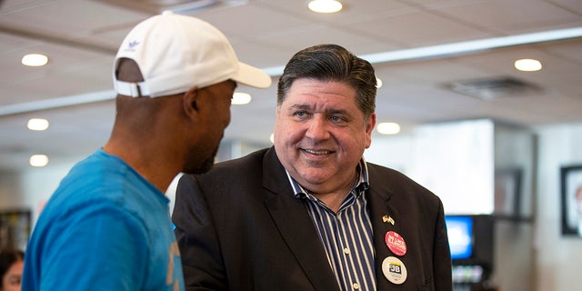 Pritzker speaks to a supporter on primary day at Manny's Deli June 28, 2022, in Chicago.