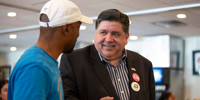 Pritzker speaks to a supporter on primary day at Manny's Deli June 28, 2022, in Chicago.