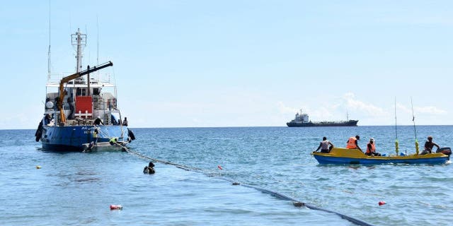 Pekerja menyiapkan kapal tunda untuk menarik kapal di pelabuhan Honiara pada 30 Agustus 2022.