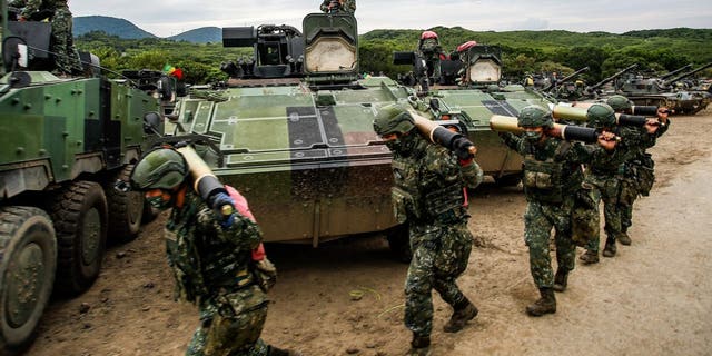 Taiwanese soldiers carry shells past armored vehicles during a two-day live-fire drill on Sept. 7, 2022.