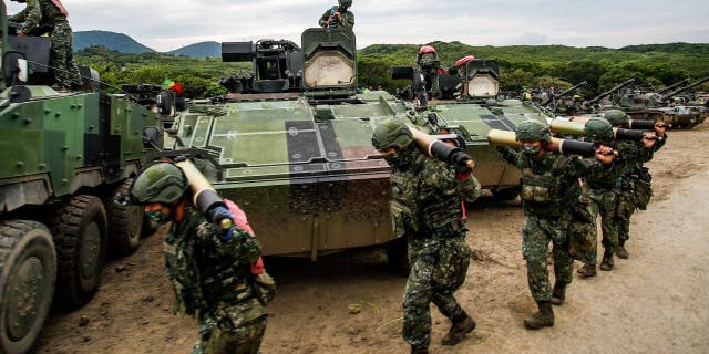 Taiwanese soldiers carry shells past armored vehicles during a two-day live-fire drill on Sept. 7, 2022.