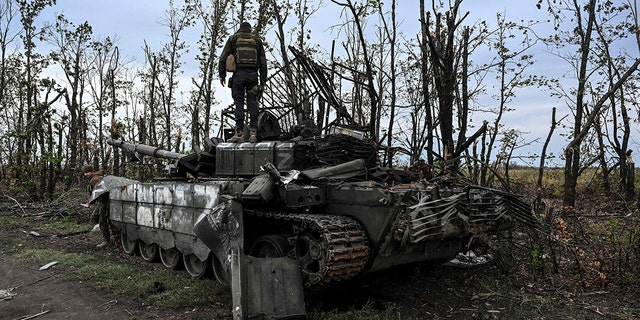This photograph taken on Sept. 11, 2022 shows a Ukrainian soldier standing on an abandoned Russian tank near a village on the outskirts of Izyum in the Kharkiv region of eastern Ukraine. 