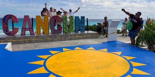 Tourists take photos at Playa Delfines in the Hotel Zone of Cancun in the state of Quintana Roo, Mexico on November 8, 2022.